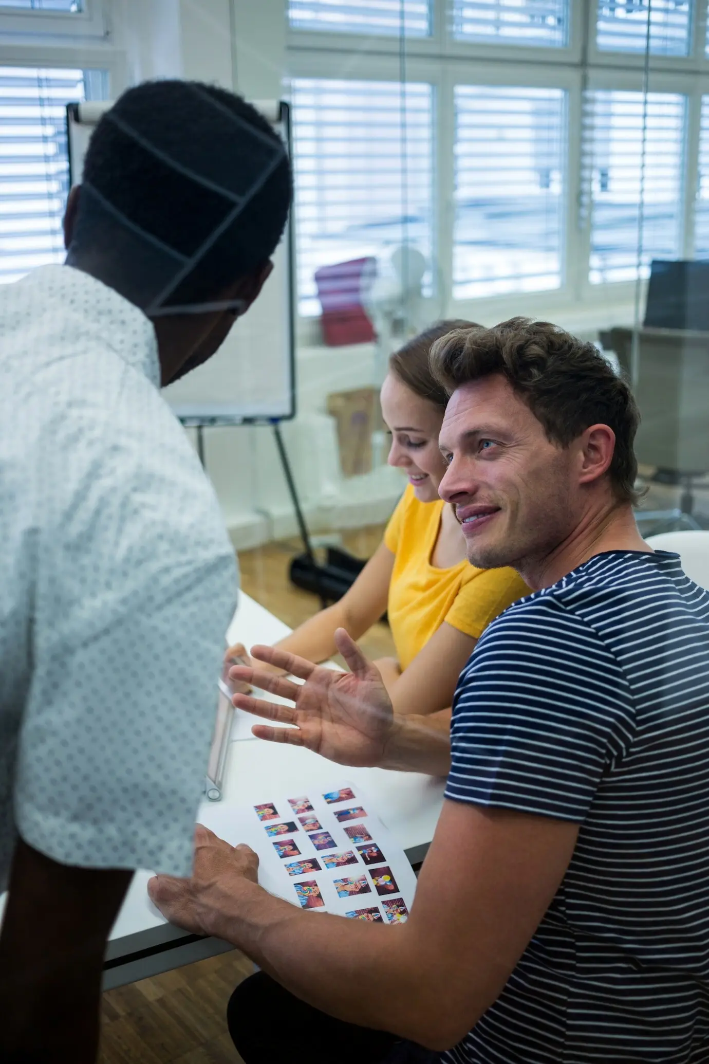 Два графических дизайнера — мужчина и женщина — взаимодействуют друг с другом.